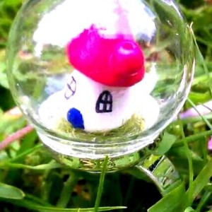 Fairy house globe ring atop faux grass